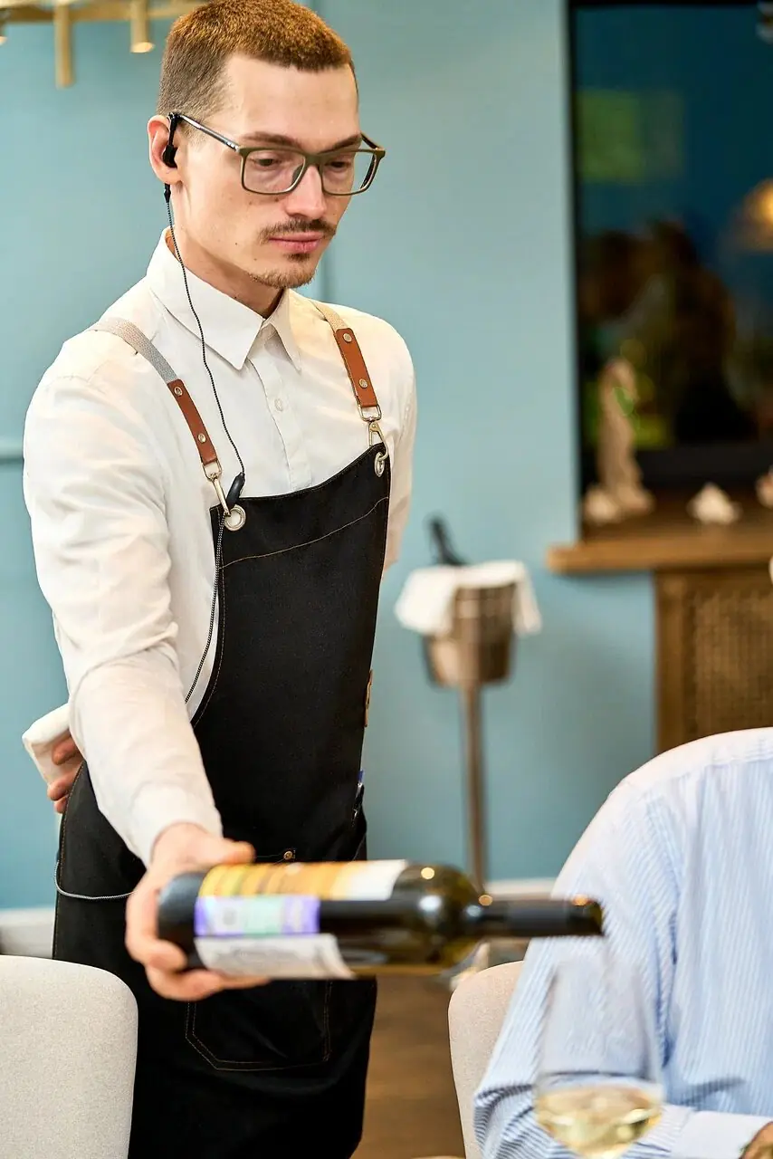 A server pours wine at the table